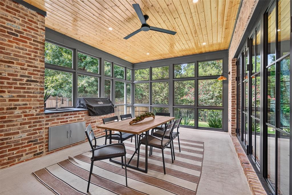 Screened porch featuring exposed brick walls, a wood-plank ceiling with recessed lighting, and large windows