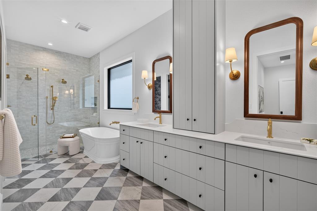 Expansive bathroom featuring a standalone soaking tub and an oversized glass-enclosed shower with gold-tone fixtures