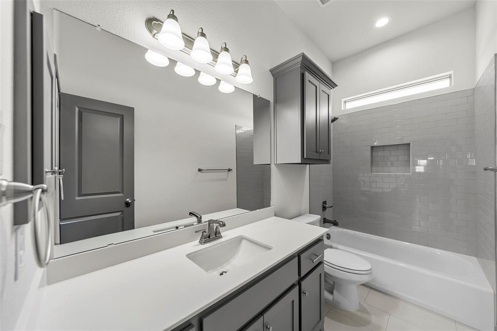 Full-width vanity mirror reflecting a gray paneled door