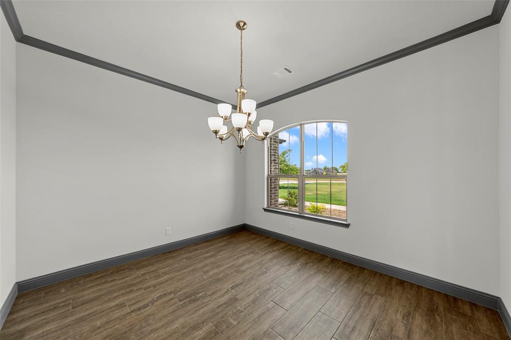 Room featuring wood-look tile flooring, gray baseboards, and gray crown molding