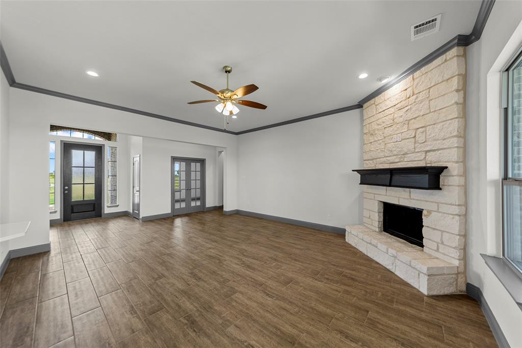 Spacious living area featuring wood-finish flooring, a ceiling fan, and recessed lighting