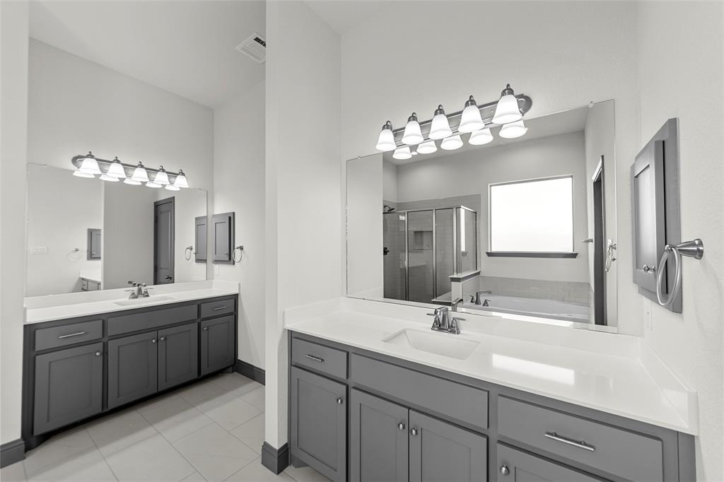 Dual vanities featuring gray cabinetry and white countertops