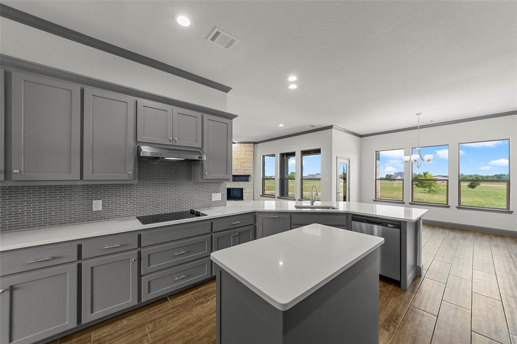 Modern kitchen featuring grey cabinetry, white countertops, and a glass tile backsplash