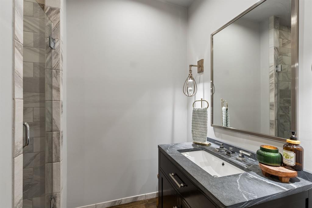 Gorgeous bathroom with soapstone countertop, modern sconces and walk-in shower!