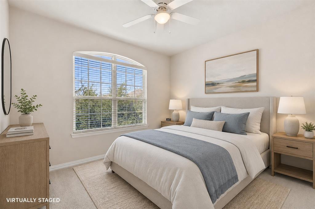 Room featuring an arched window, ceiling fan with integrated lighting, and neutral wall tones