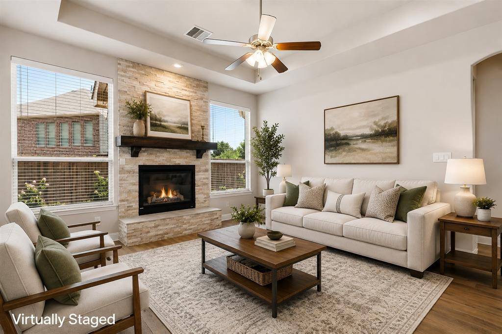 Living area featuring a stone-clad fireplace with a wood mantel, wood-finish flooring, a ceiling fan, and recessed lighting