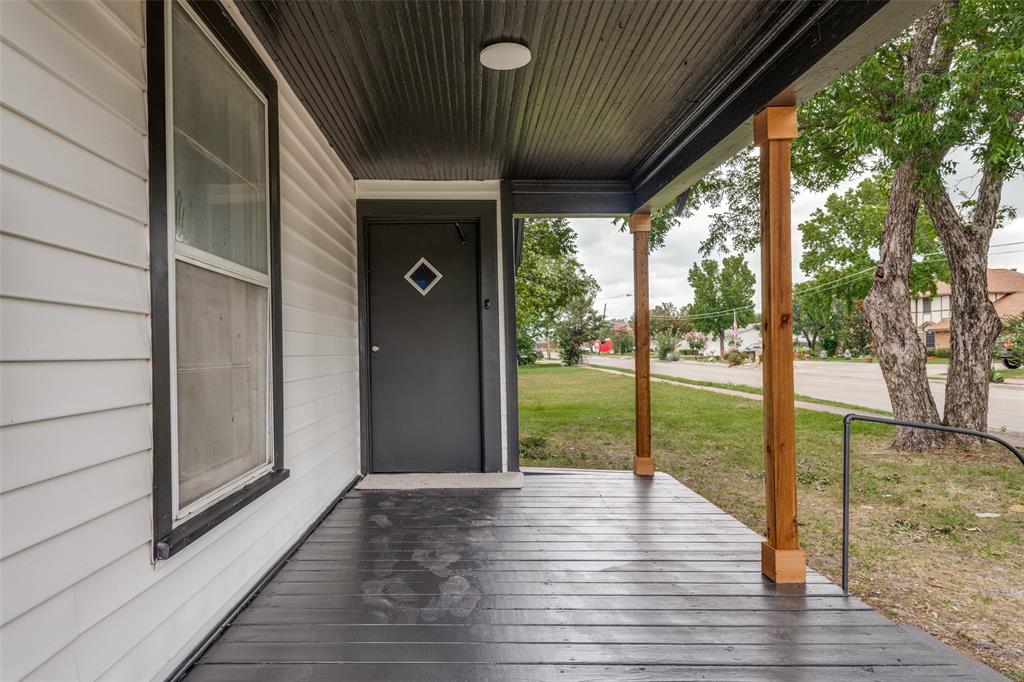 Covered front porch featuring wood-finish support columns and a dark painted floor Covered front porch featuring wood-finish support columns and a dark painted floor
