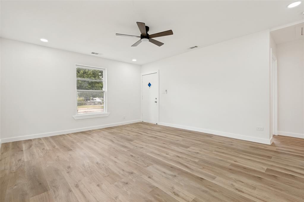 Spacious room featuring wood-finish flooring, recessed lighting, and a contemporary ceiling fan Spacious room featuring wood-finish flooring, recessed lighting, and a contemporary ceiling fan