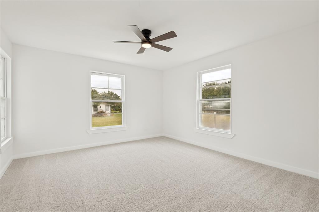 Spacious room featuring light-toned carpet flooring and white painted walls