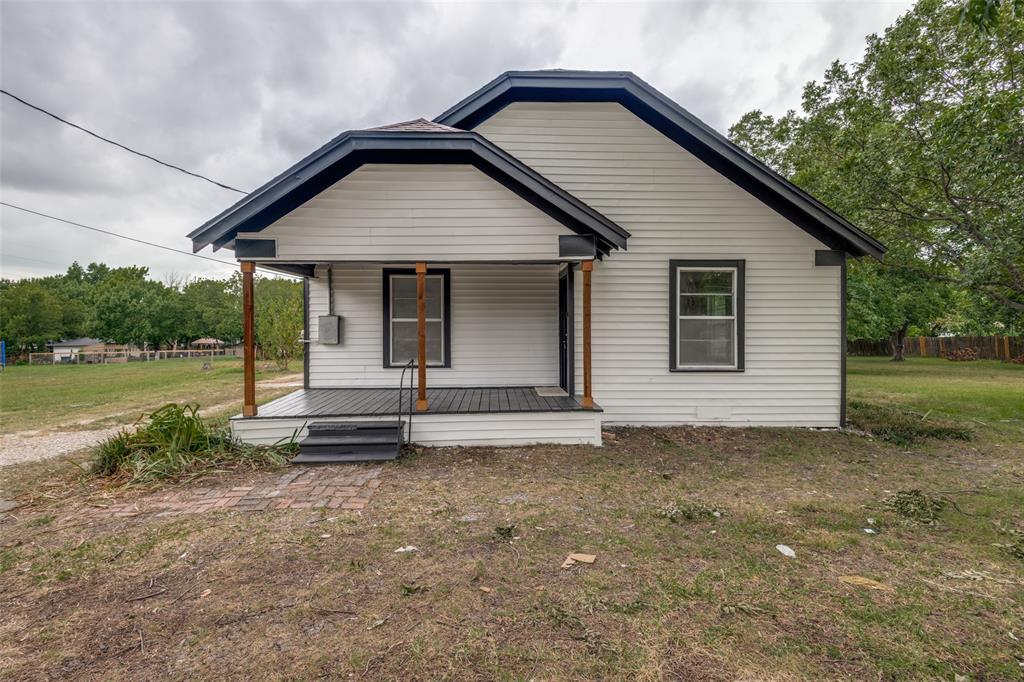 White siding exterior featuring a covered porch with dark flooring and wooden support beams White siding exterior featuring a covered porch with dark flooring and wooden support beams