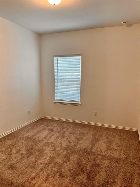 Room featuring neutral-toned walls, brown carpet, and white baseboards