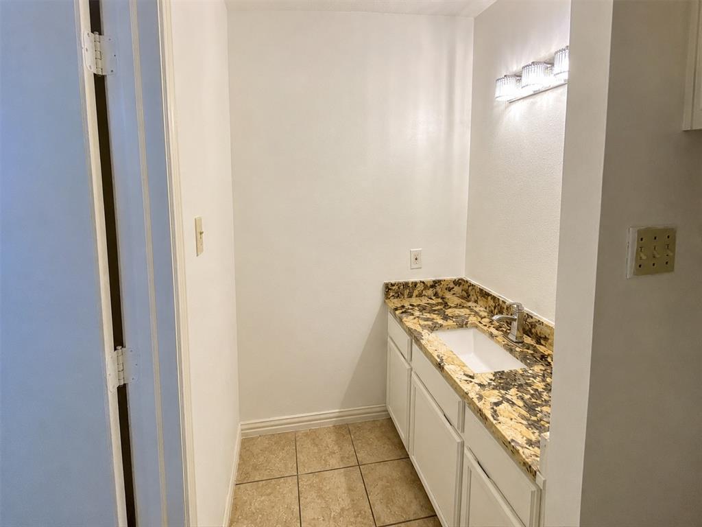 Vanity area featuring a gold and brown patterned countertop, undermount sink, and polished chrome faucet Vanity area featuring a gold and brown patterned countertop, undermount sink, and polished chrome faucet