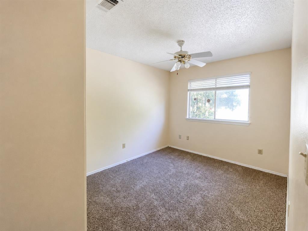 Carpeted room featuring a window with horizontal blinds, a ceiling fan with integrated lighting, and neutral-toned walls Carpeted room featuring a window with horizontal blinds, a ceiling fan with integrated lighting, and neutral-toned walls