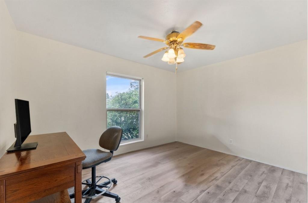 Wood-finish flooring, single window, ceiling fan with light fixture, and neutral wall tones