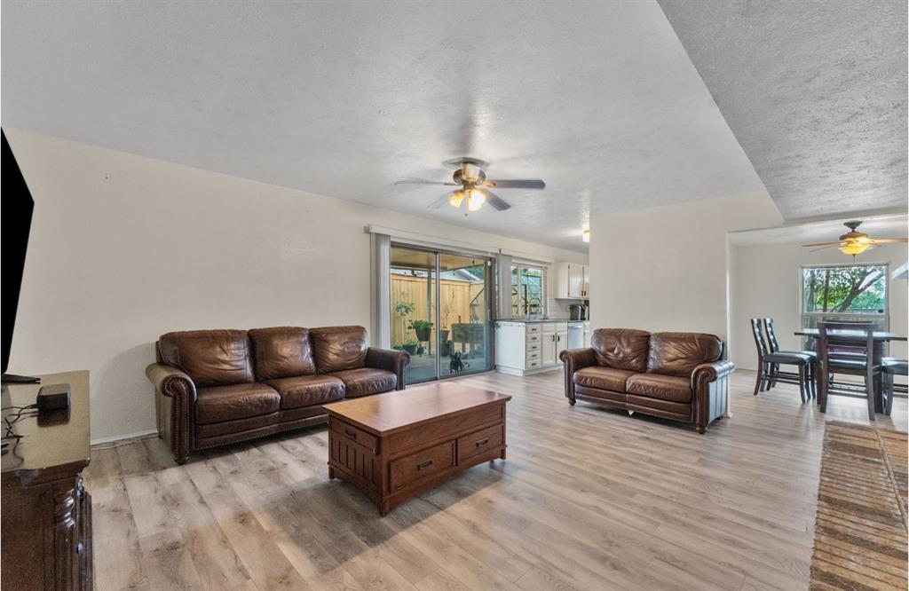 Wood-finish flooring, ceiling fan, sliding glass door, and a dining area Wood-finish flooring, ceiling fan, sliding glass door, and a dining area