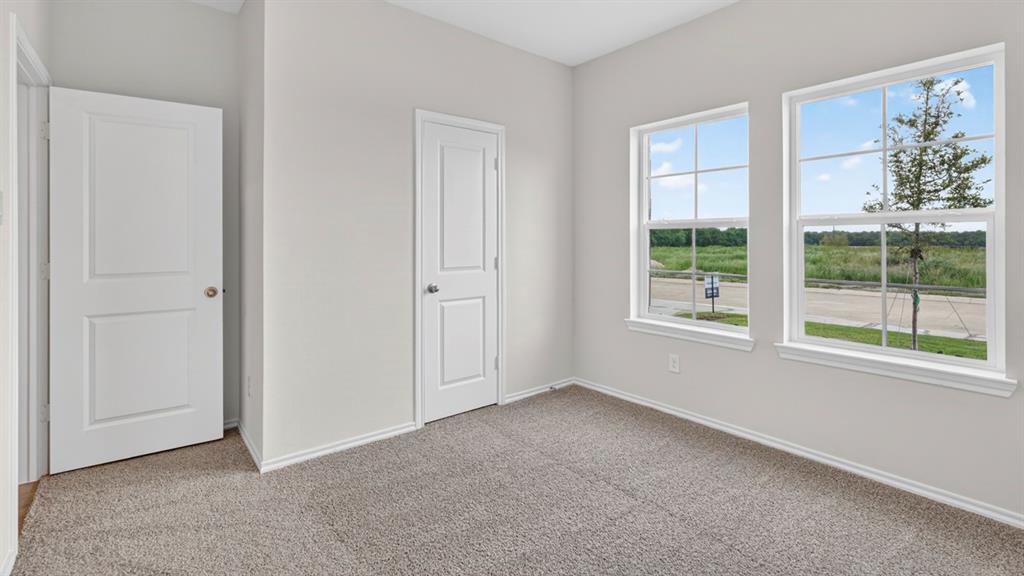 Bright interior space featuring two panel doors, light gray wall paint, and gray carpet flooring