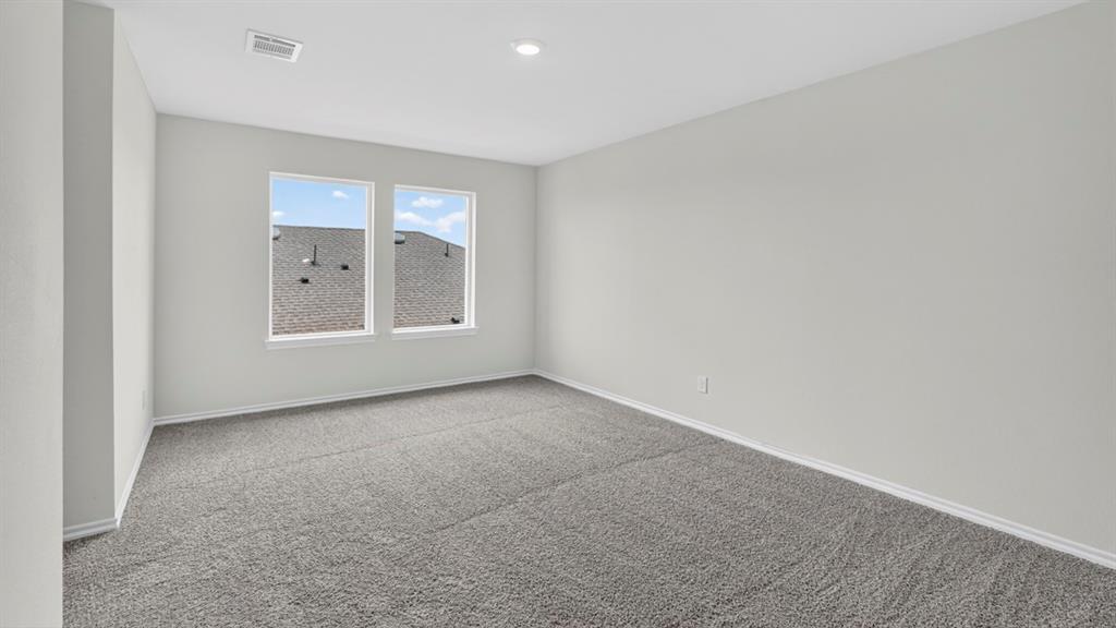 Bright interior space featuring light gray wall paint, crisp white trim, and plush gray carpeting