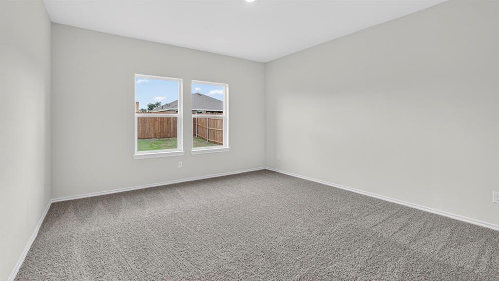 Spacious room featuring neutral carpeting, light gray wall paint, and two double-hung windows