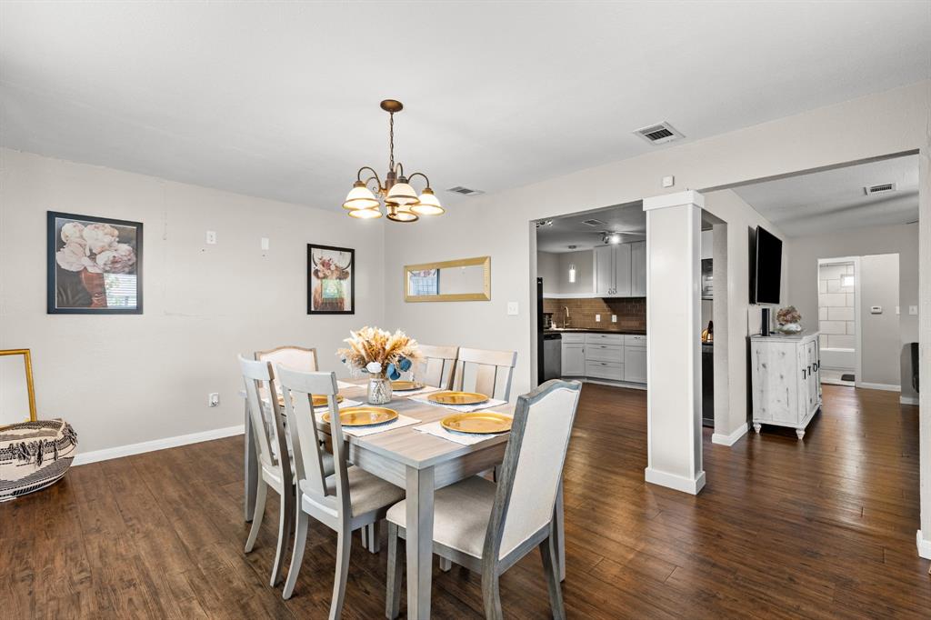 Dining area featuring wood-finish flooring and a ceiling-mounted chandelier Dining area featuring wood-finish flooring and a ceiling-mounted chandelier