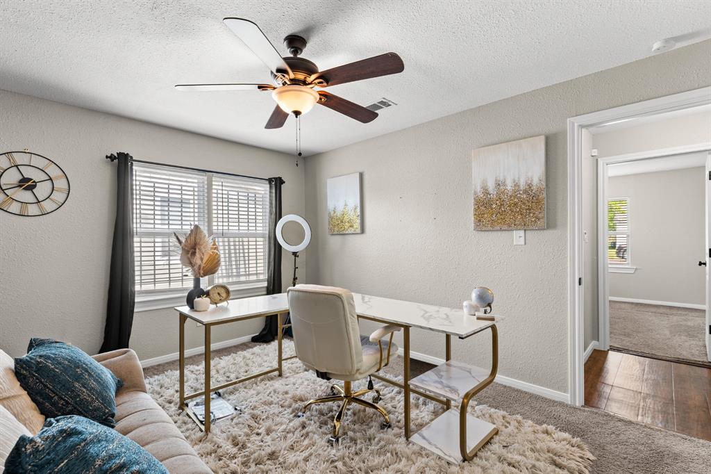 Room featuring light-colored walls, window with blinds, and a dark-bladed ceiling fan with integrated lighting