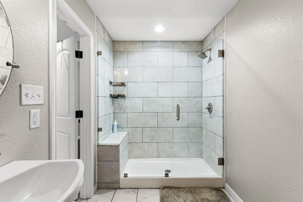 Contemporary shower enclosure featuring glass panels and a built-in bench