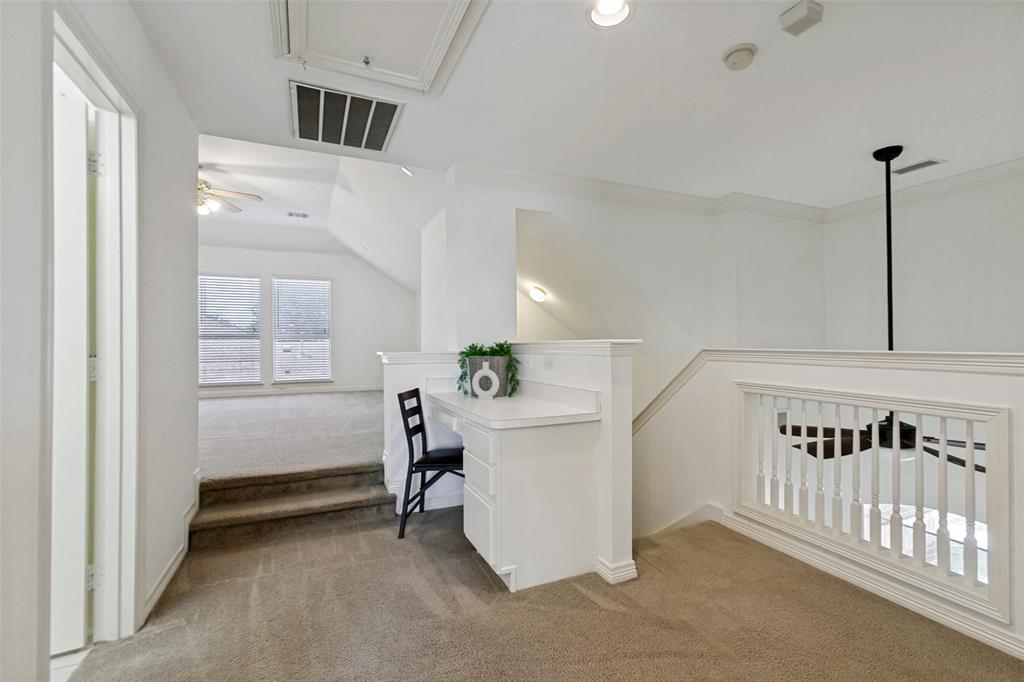A built in desk is featured at the top of the stairs