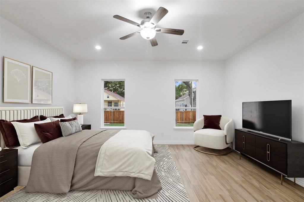 Spacious bedroom with wood-finish flooring, two windows, recessed lighting, and a ceiling fan