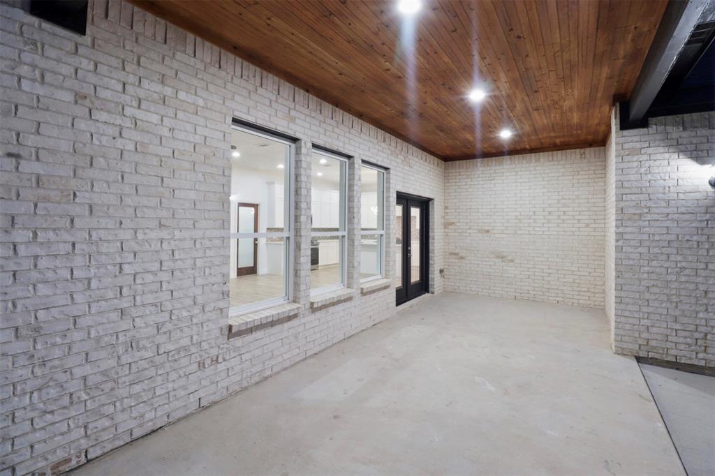 Spacious open floor plan featuring white brick walls, polished concrete flooring, and a wood-finish coffered ceiling with recessed lighting