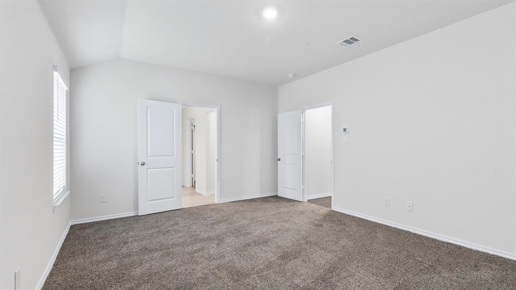 Spacious room featuring vaulted ceilings, a window with blinds, recessed lighting, and soft grey carpet flooring