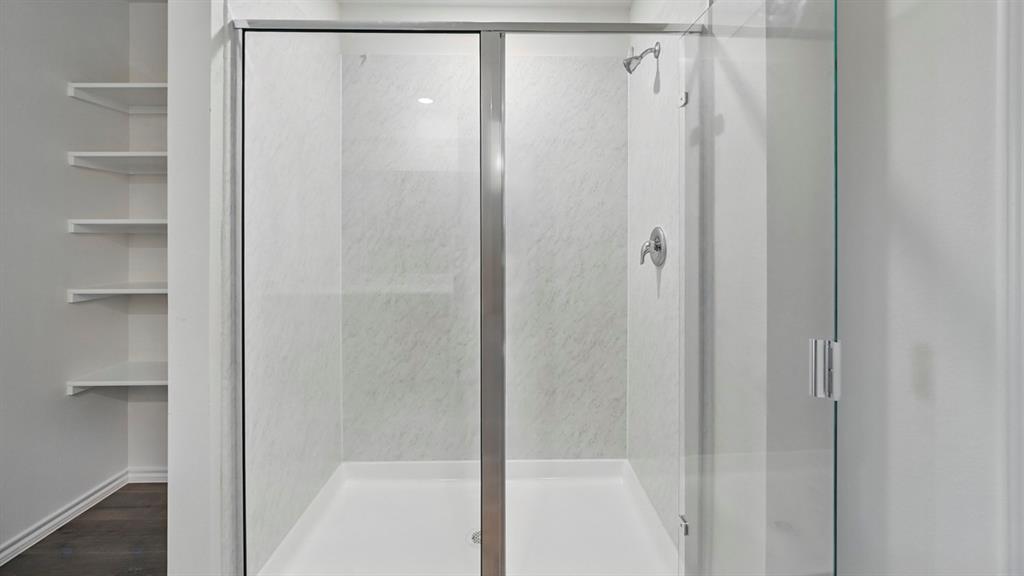 Glass-enclosed shower with a chrome showerhead and control Glass-enclosed shower with a chrome showerhead and control