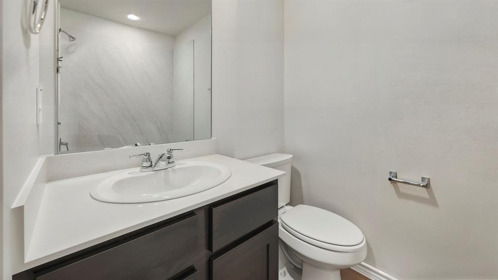 Bathroom vanity featuring a white oval sink, chrome faucet, and white countertop Bathroom vanity featuring a white oval sink, chrome faucet, and white countertop