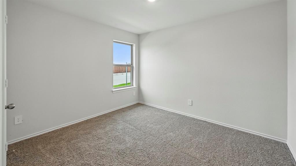 Neutral tone walls with white trim, gray textured carpet flooring, and a single window