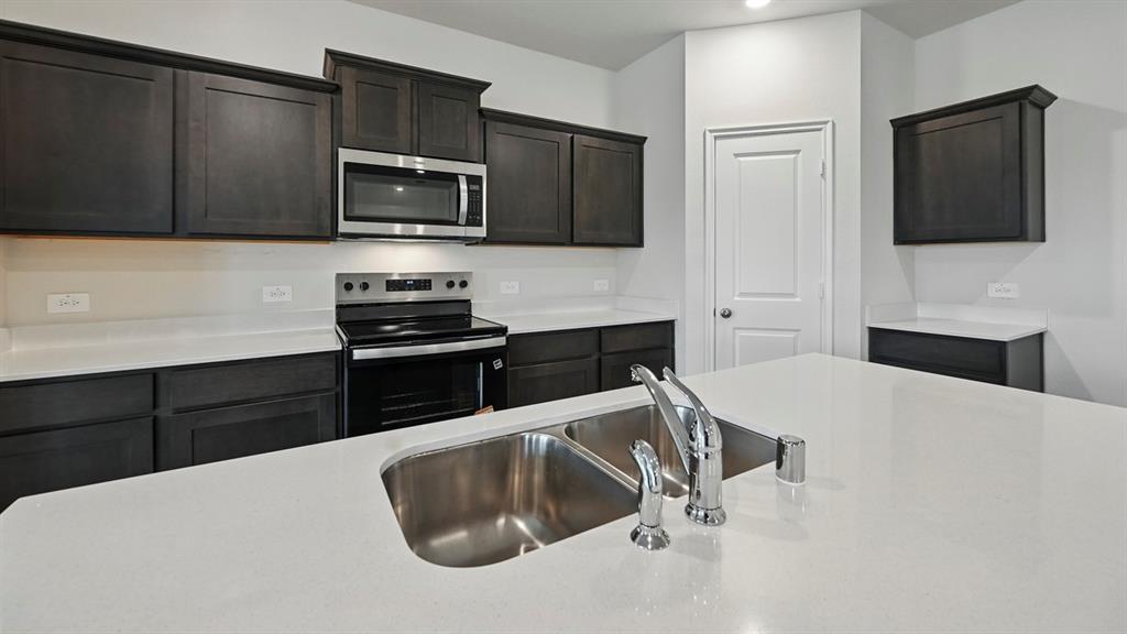 Kitchen island featuring a double basin stainless steel sink with a gooseneck faucet