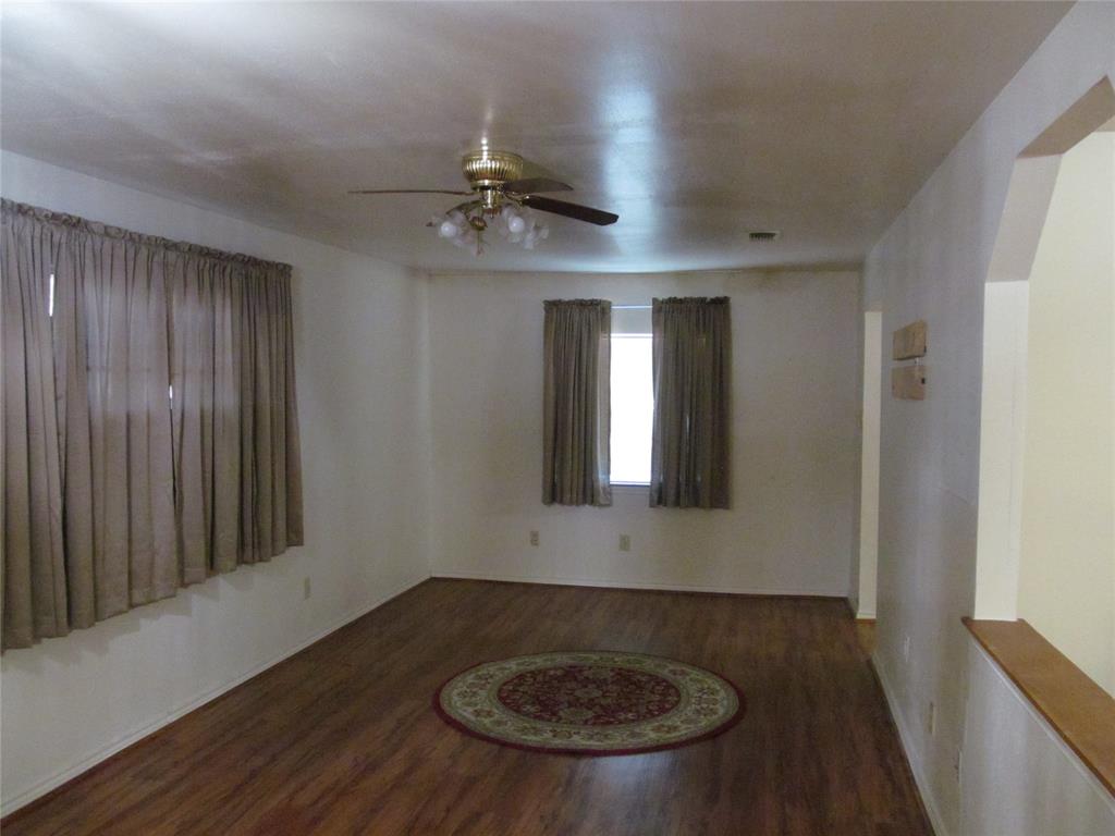 Wood-finish flooring with an arched doorway and a ceiling fan FAMILY ROOM OR DEN