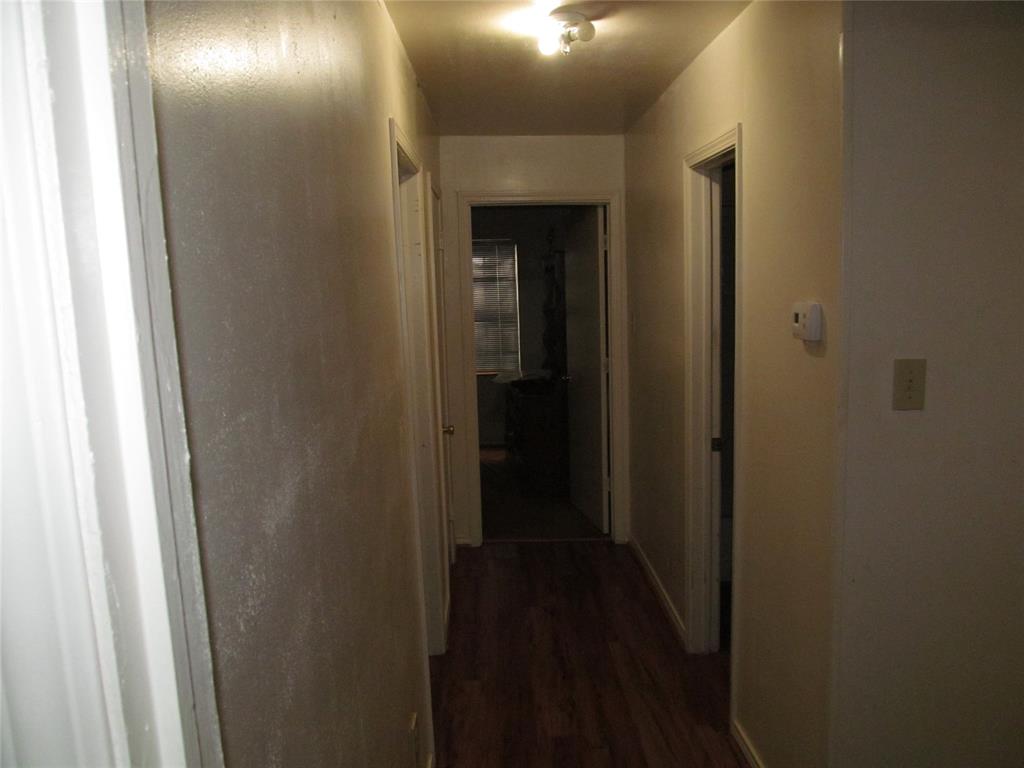 Hallway with wood-finish flooring and multiple doorways - BEHIND THE PHOTO IS  BEDROOM #2   TO THE  LEFT IN HALLWAY IS BEDROOM #3  , TO THE RIGHT IS THE SECOND FULL BATH WITH COMBO TUBSHOWER, AND AHEAD IS BEDROOM #4