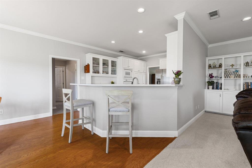 Kitchen featuring white cabinetry, a peninsula breakfast bar, stainless steel appliances, and recessed lighting