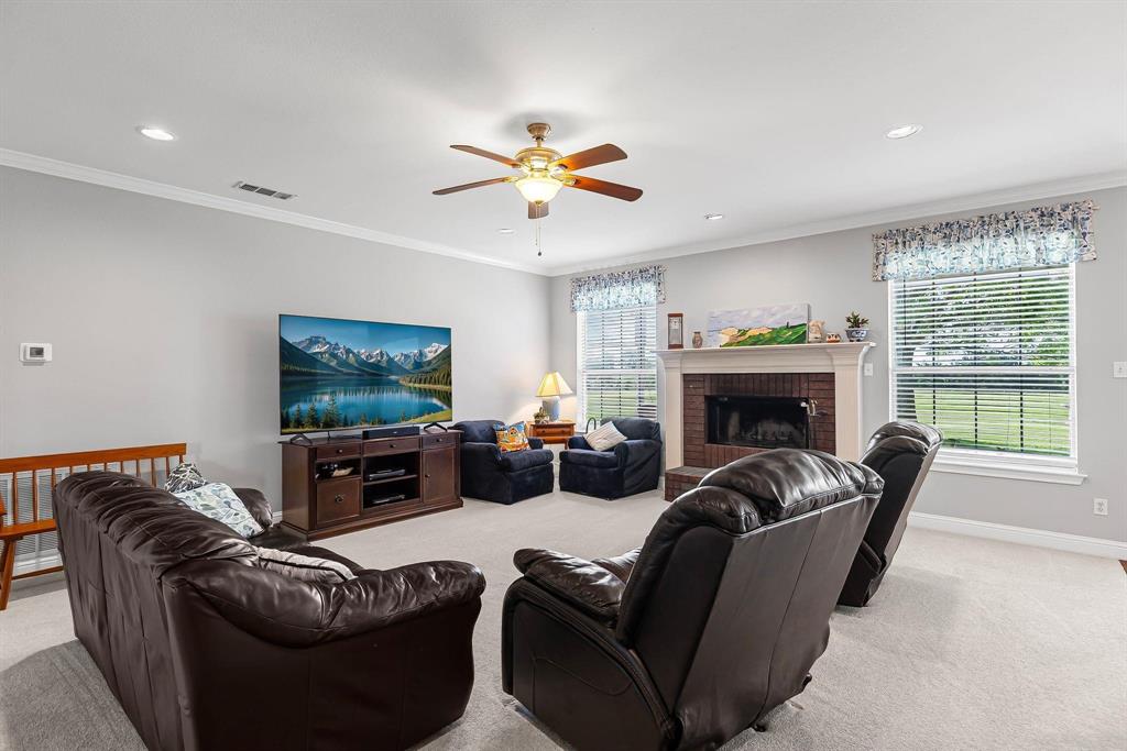 Living space featuring a brick fireplace with a white mantel, recessed lighting, and a ceiling fan