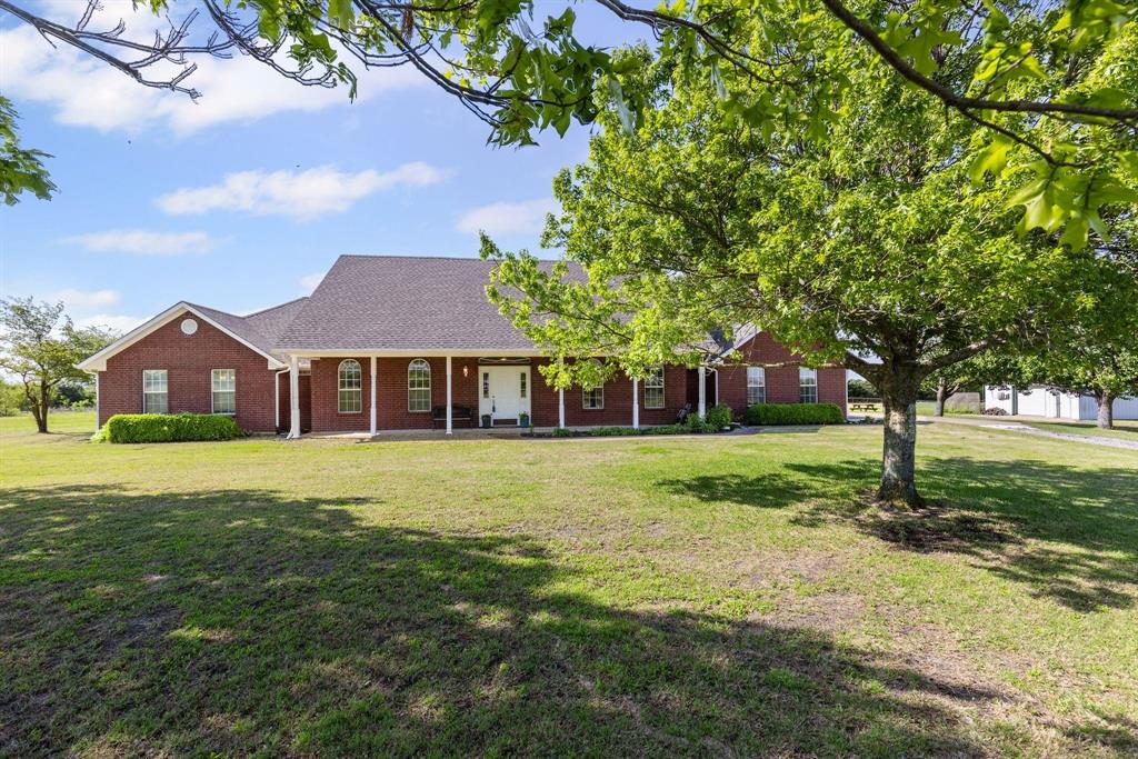 Brick exterior featuring a covered porch with white columns and arched windows