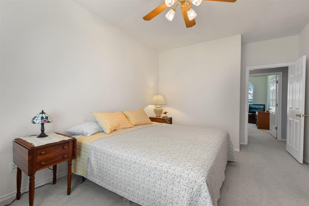 Wall-to-wall carpeting and a ceiling fan with integrated lighting fixtures