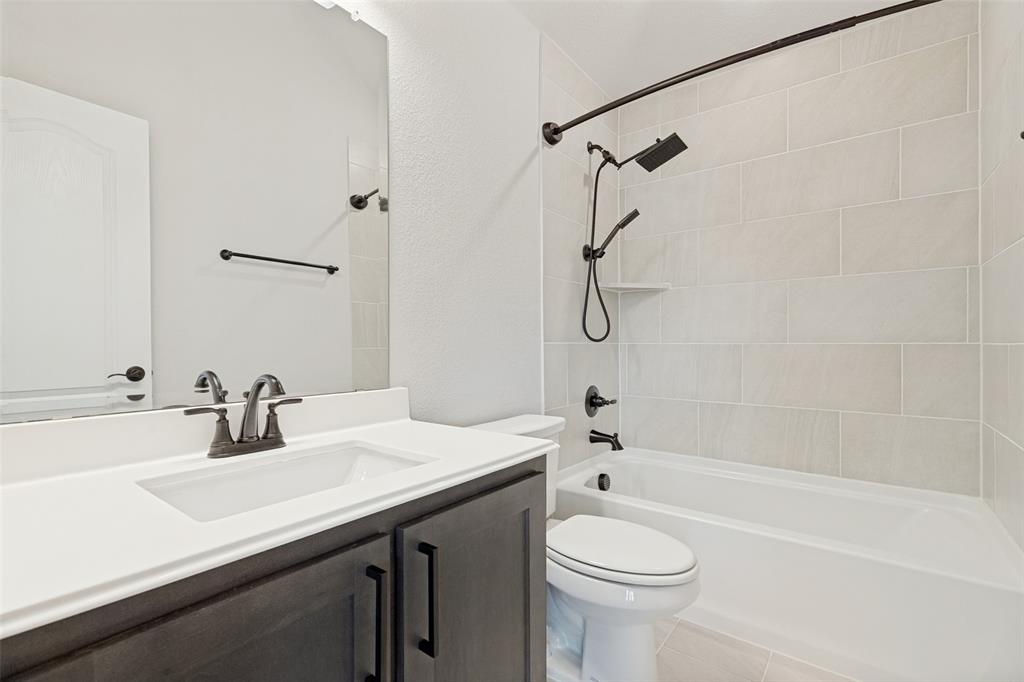 Bathroom featuring a single vanity with a white countertop and dark wood-finish cabinetry