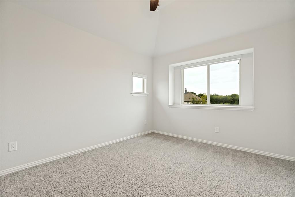 Room featuring light gray carpeting, vaulted ceiling, and white painted walls