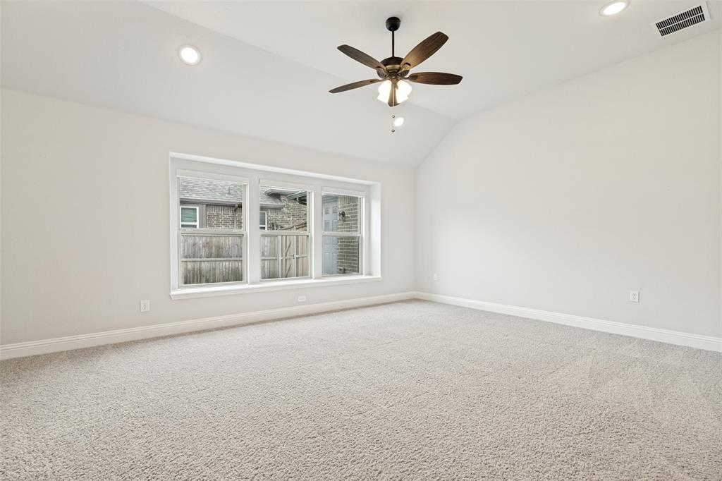 Carpeted room featuring a vaulted ceiling with a ceiling fan, recessed lighting, and a triple window unit with white trim