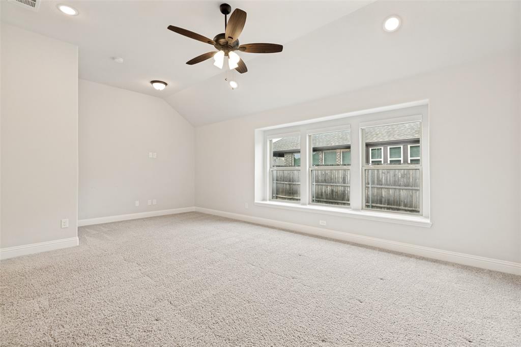 Spacious room featuring vaulted ceilings, recessed lighting, and a ceiling fan with integrated lighting