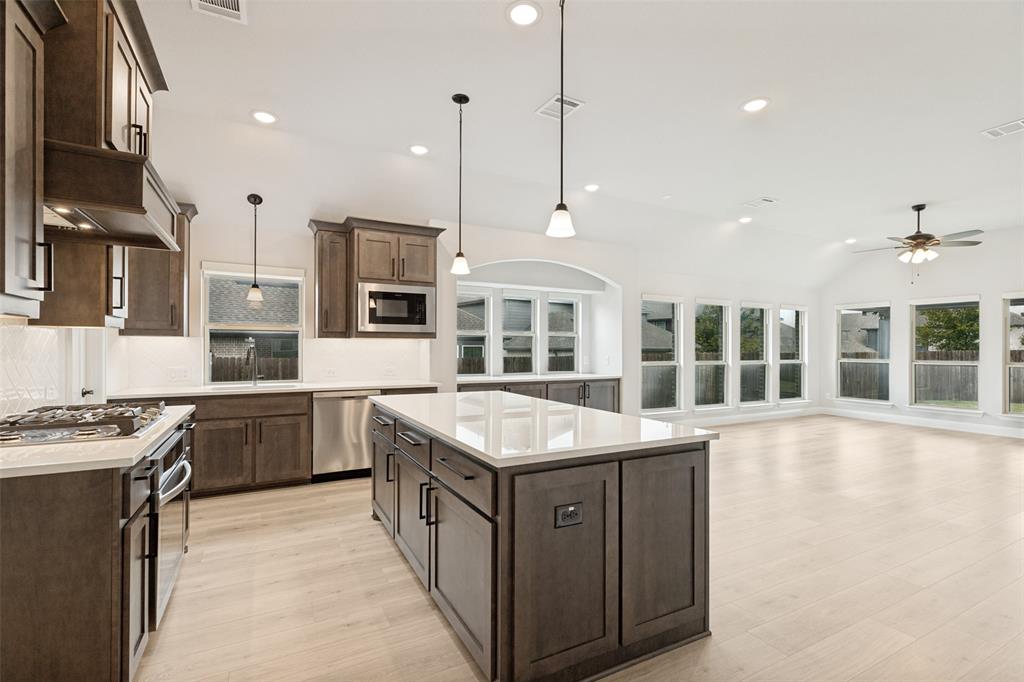 Open-concept kitchen featuring an island, recessed lighting, and wood-finish flooring