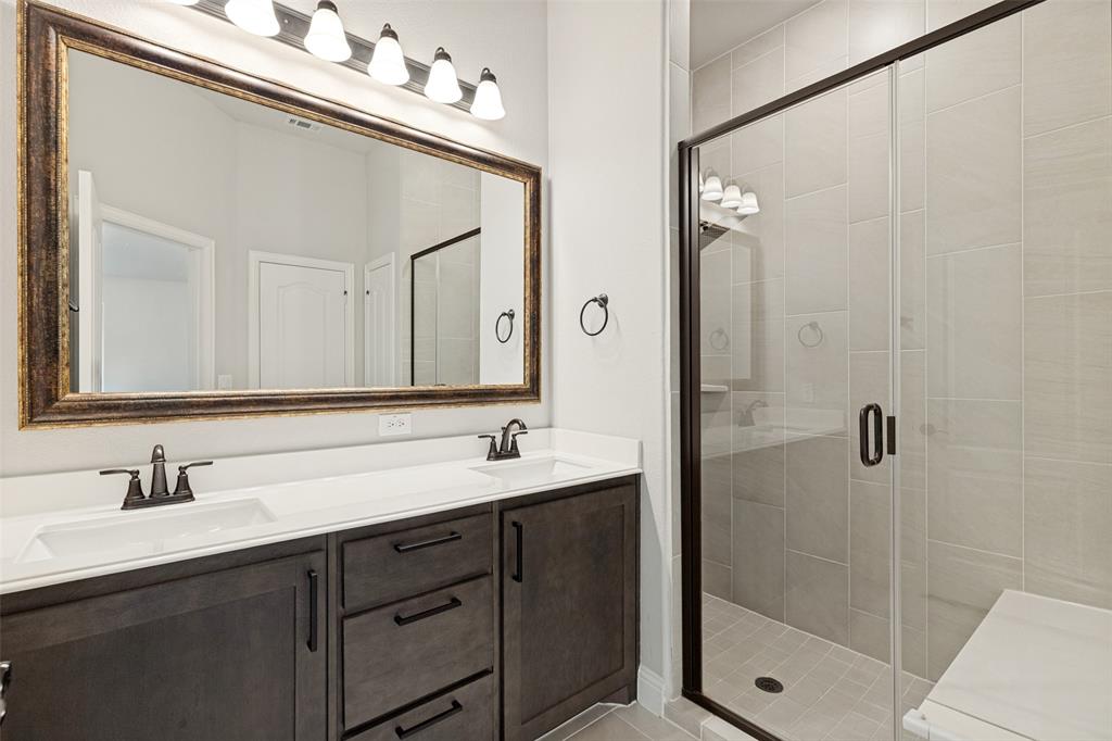 Modern bathroom featuring a dual vanity with dark wood-finish cabinetry, white countertops, and undermount sinks
