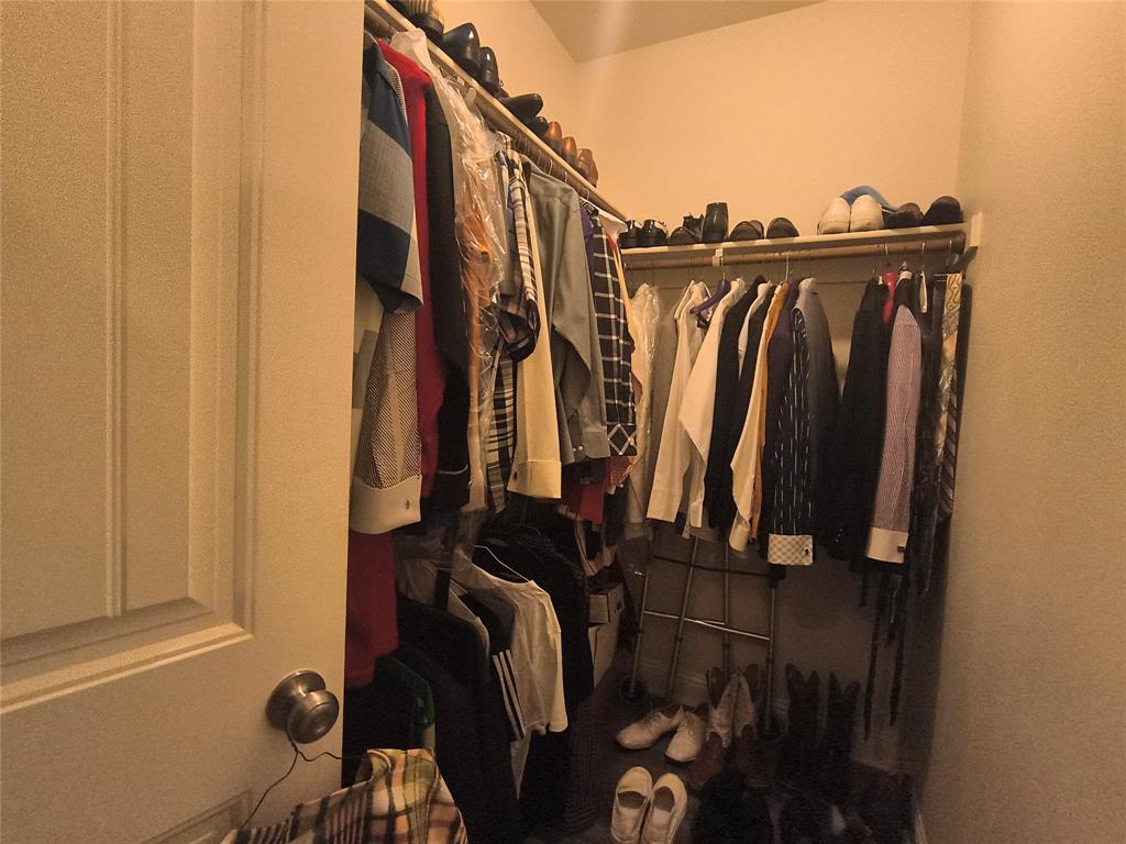 Walk-in closet featuring extensive shelving and multiple clothing rods