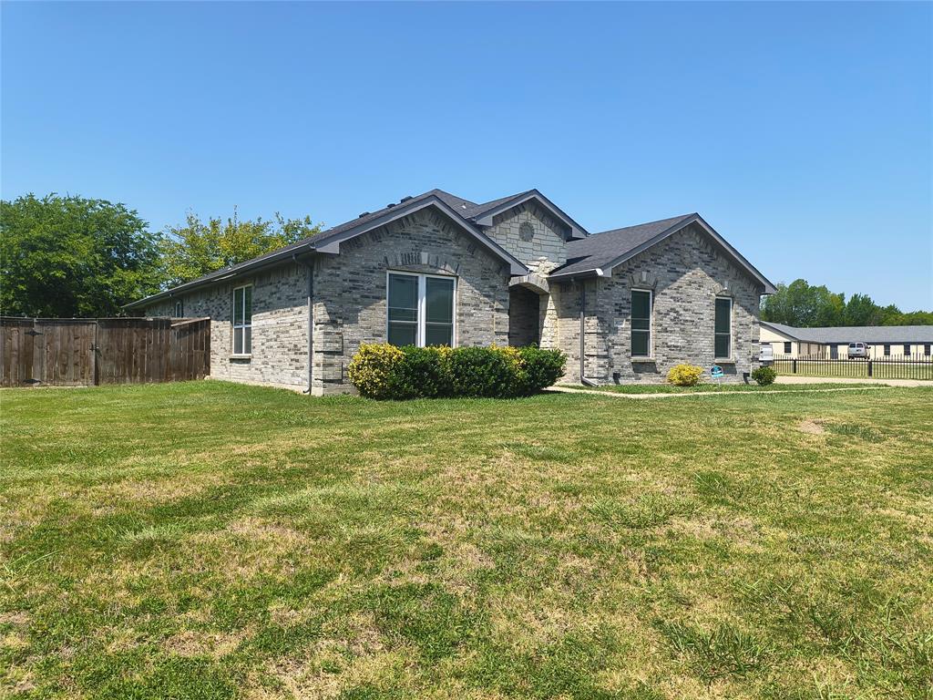 Gray brick exterior with dark shingle roofing