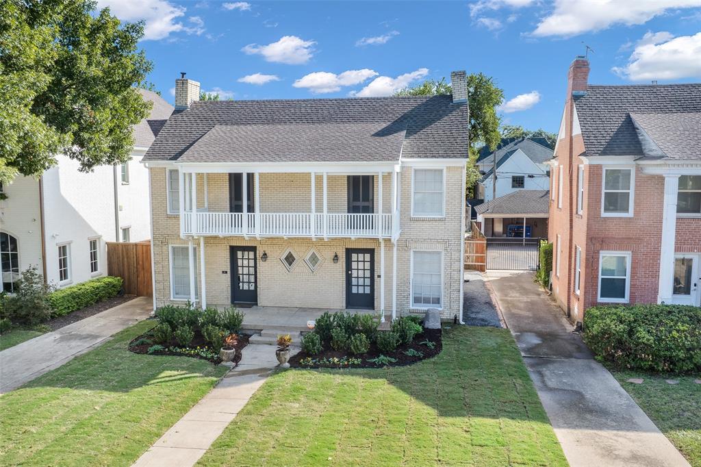 Traditional brick exterior featuring a covered upper-level balcony, dual-entry French doors, diamond-shaped accent windows, and a paved private driveway Traditional brick exterior featuring a covered upper-level balcony, dual-entry French doors, diamond-shaped accent windows, and a paved private driveway