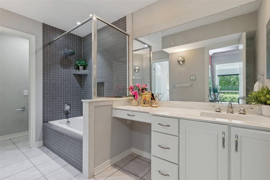White cabinetry with chrome hardware, separate shower, toilet, and a large vanity mirror