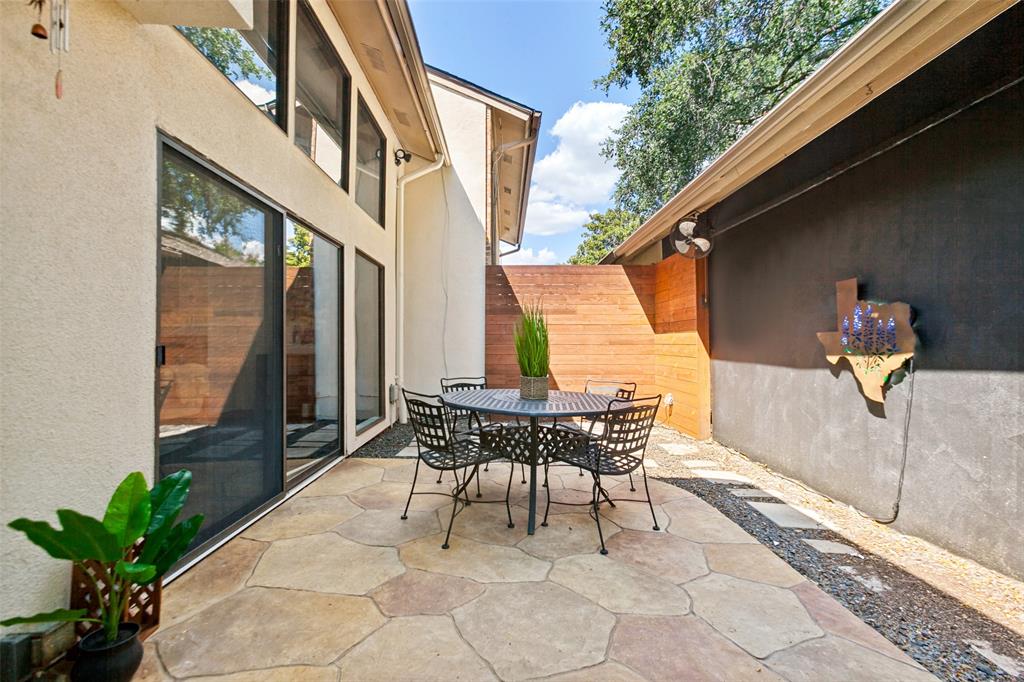 Stamped concrete patio with a privacy fence, stucco exterior, and sliding glass doors